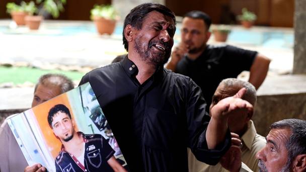 A father holds a poster of his dead son who was an Iraqi soldier at a courtroom in Baghdad