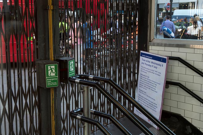 A notice providing strike information is seen behind closed shutters at St Paul’s underground station during a tube strike in London. — AFP