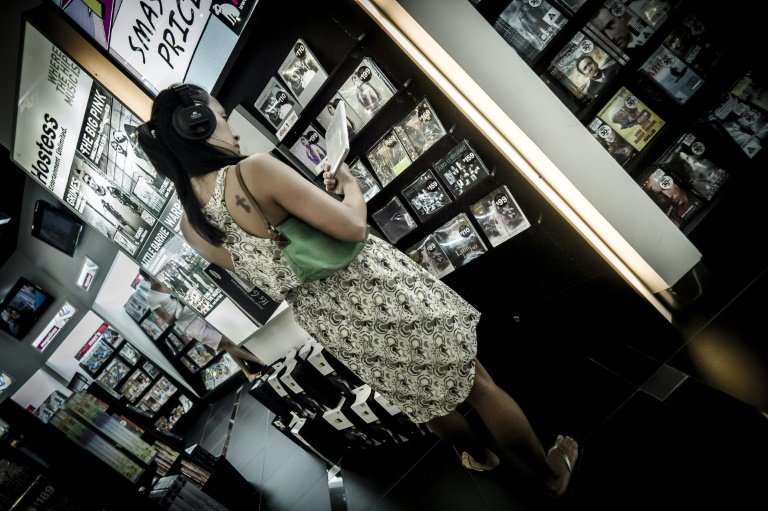 A woman listens to a music CD in a shop in Hong Kong