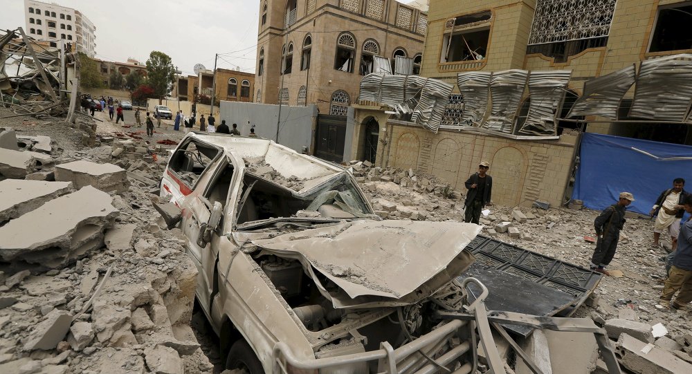 Houthi militants and people gather at the site of a Saudi-led air strike in Yemen's capital Sanaa