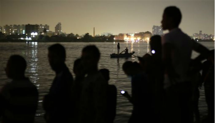 Egyptian volunteers look for victims of a passenger boat after it sank in the river Nile in Giza south of Cairo Egypt Thursday