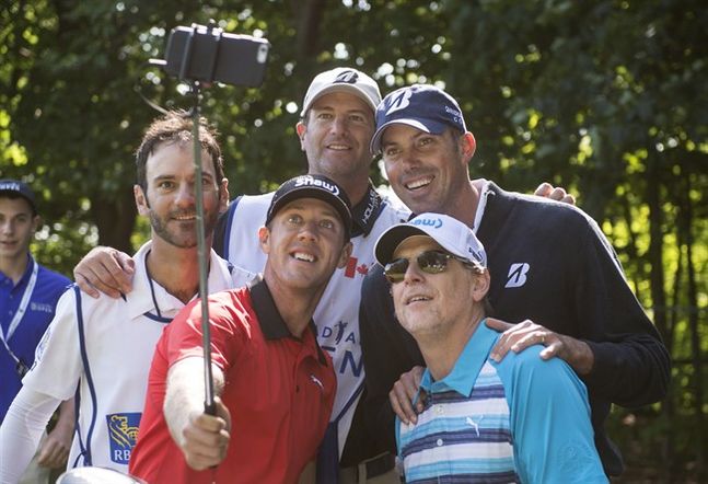 Canadian Graham De Laet from Weyburn Sask takes a selfie with fellow golfer Matt Kuchar top right of the USA and caddies during the Pro Am at the Canadian Open golf tournament Wednesday