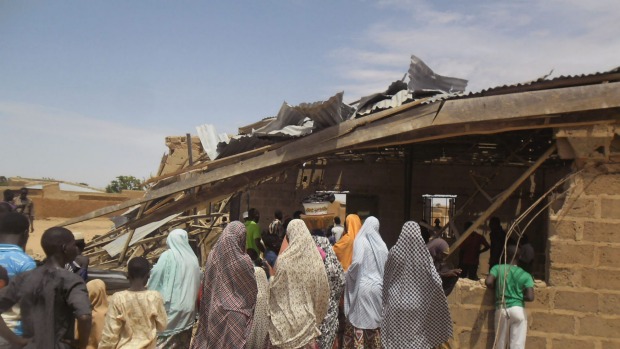 People gather around the Redeemed Christian Church of God after a woman suicide bomber killed five people in Potiskum Nigeria. It was the first in a string of attacks on Sunday that killed 44