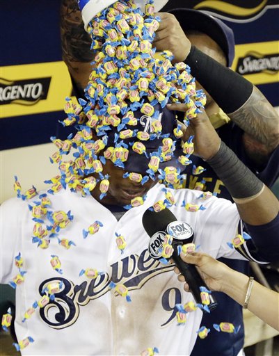 Milwaukee Brewers&#039 Martin Maldonado pours bubble gum on teammate Jean Segura during a TV interview after a baseball game against the Cleveland Indians Tuesday