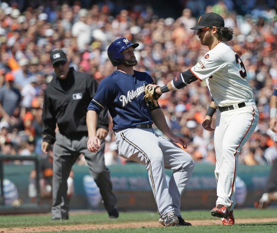 Milwaukee Brewers Shane Peterson left is tagged out by San Francisco Giants shortstop Brandon Crawford on a rundown between home plate and third base on a fielder's choice in the eighth inning of a baseball game Wednesday