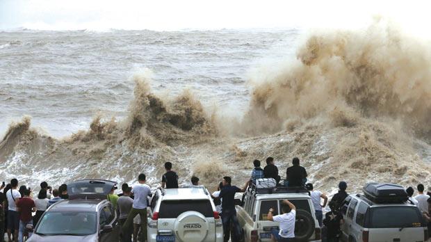 People look on as waves under the influence of typhoon Chan-hom hit the shore in Wenling Zhejiang province China