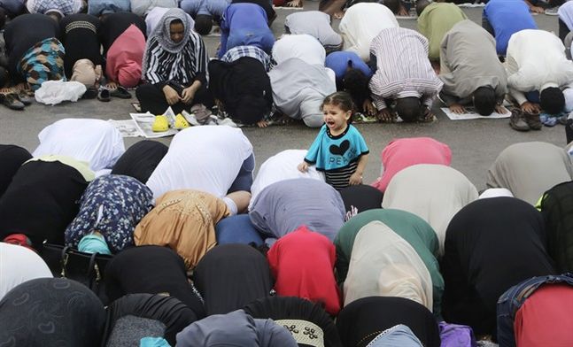 An Egyptian girl cries as her mother joins others offering an Eid al Fitr prayer marking the end of the Muslim holy month of Ramadan in Cairo Egypt Friday