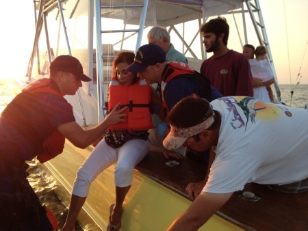 Crew from Station Chincoteague assist a wounded woman onto their 24-foot Special Purpose Craft. The pleasure craft CHASER ran aground during the 2015 Chincoteague Pony Swim with six adults on board and two children