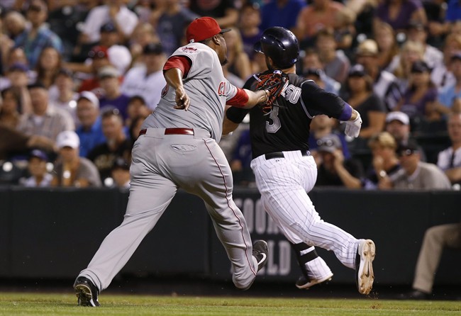 Cincinnati Reds relief pitcher Jumbo Diaz left tags out Colorado Rockies pinch hitter Daniel Descalso who runs toward first base in the ninth inning of a baseball game Saturday