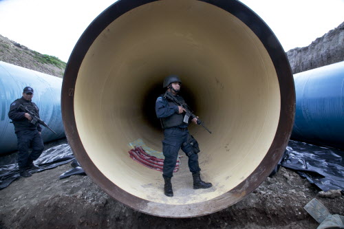 Federal police guard a drainage pipe outside of the Altiplano maximum security prison in Almoloya west of Mexico City Sunday