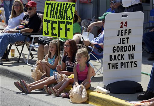 Fans sit on the curb as they await the arrival of NASCAR driver Jeff Gordon during parade in his honor in Pittsboro Ind. Thursday