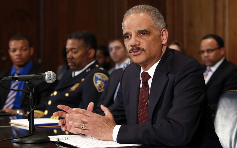 U.S. Attorney General Eric Holder arrives to talk to the media about the shooting of two police officers in Ferguson and to announce pilot cities for DOJ program to build trust between law enforcement and communities they serve at the Justice Department