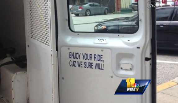 In this image from WBAL-TV's report a sign inside a Baltimore police van reads'Enjoy your ride cuz we sure will