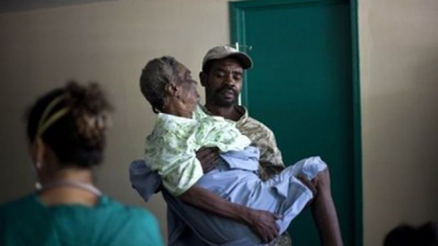 2010 a woman suffering from cholera symptoms is carried by a volunteer at the hospital in Archaie Haiti