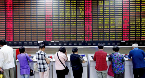 Investors look at computer screens showing stock information at a brokerage house in Shanghai China