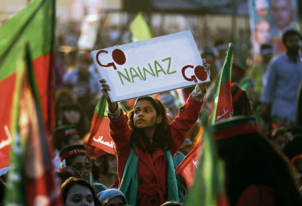 A young supporter of Pakistani politician Imran Khan raises a placard during an anti-government rally in Islamabad Pakistan 30 November 2014. A judicial commission has rejected opposition allegations of fraud during the 2013 parliamentary election