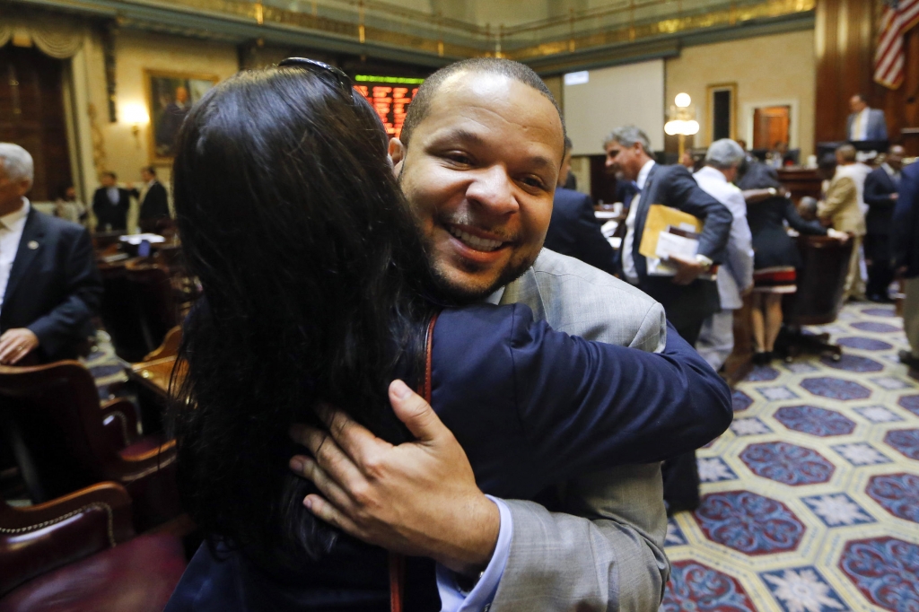 State Rep. John King D-York hugs a woman after the House approved a bill removing the Confederate flag from the Capitol grounds early Thursday in Columbia S.C