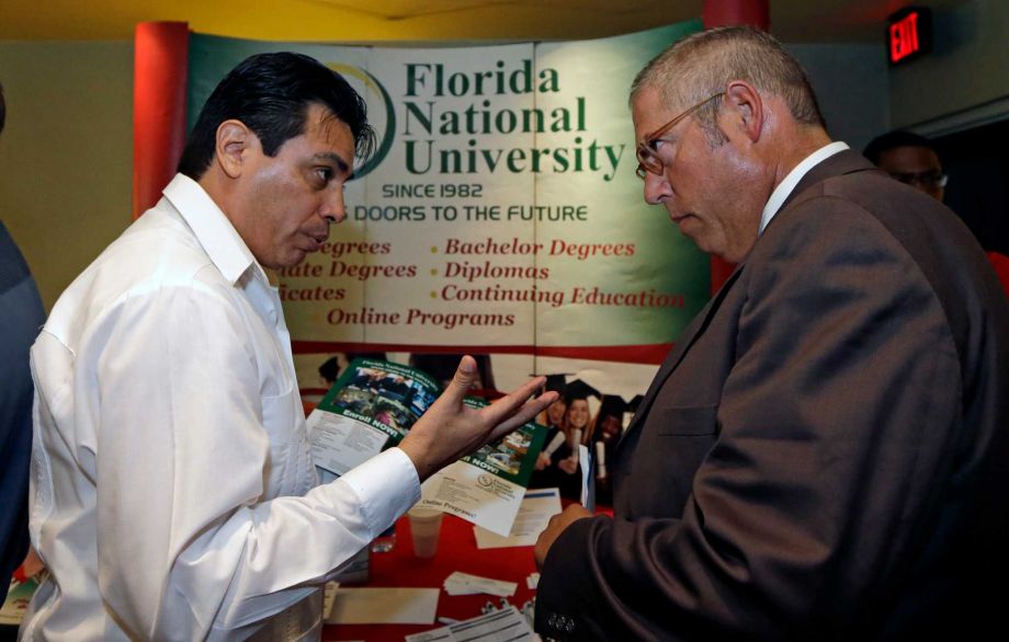 15 2015 Luigi Valdivieso left talks about job opportunities to Richard Solano at a job fair in Miami Lakes Fla. The Labor Department reports on state unemployment rates for June on Tuesday