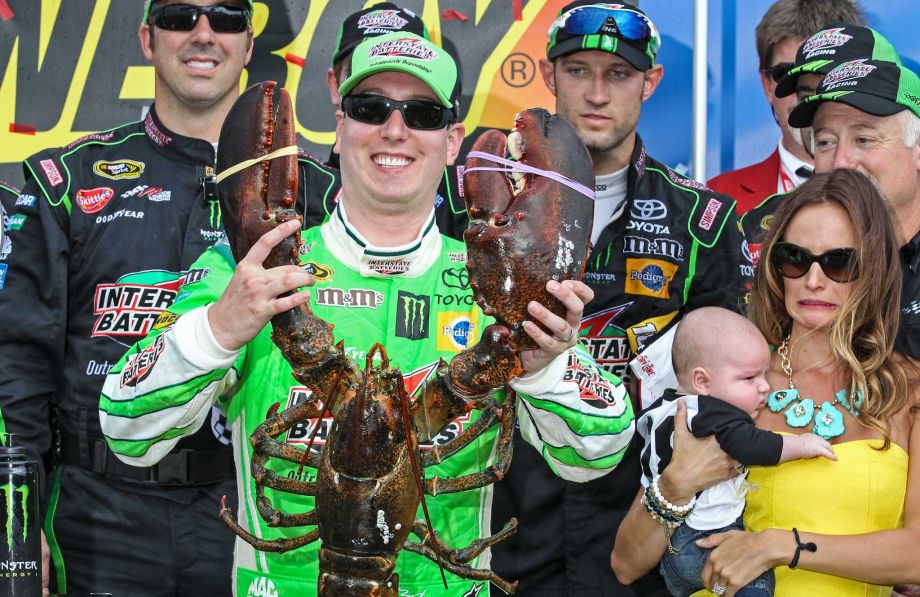 While Kyle Busch appears to be having fun with the Loudon lobster trophy in Victory Lane after winning Sunday's Sprint Cup race his wife Samantha holding their son Brexton casts a wary eye