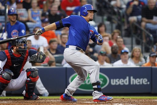 Chicago Cubs&#039 Kyle Schwarber hits a single in front of Atlanta Braves catcher A.J. Pierzynski during the third inning of a baseball game Friday