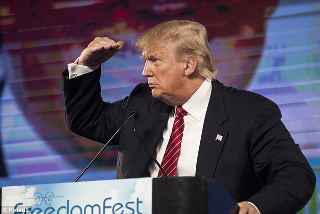 Polarizing Republican presidential candidate Donald Trump shades his eyes from the lights to see an audience member during a question and answer session following his speech at FreedomFest