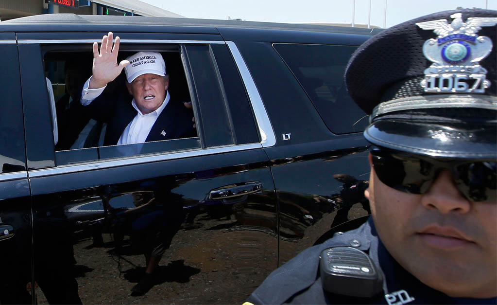 Republican presidential hopeful Donald Trump waves from his vehicle during a tour of the the World Trade International Bridge at the U.S. Mexico border in Laredo Texas