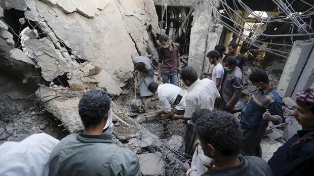 People search for survivors under the rubble of the collapsed house after it was hit by a Saudi-led air strike in Sanaa yesterday