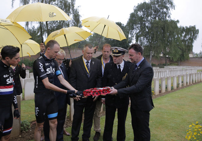 Britain's Christopher Froome second left and Peter Kennaugh left lay a wreath at the World War I Arras Memorial as Tour de France director Christian Prudhomme third right watches prior to the start of the fifth stage of the Tour de France cycling