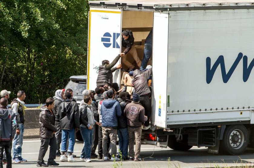 Migrants board a lorry in Calais