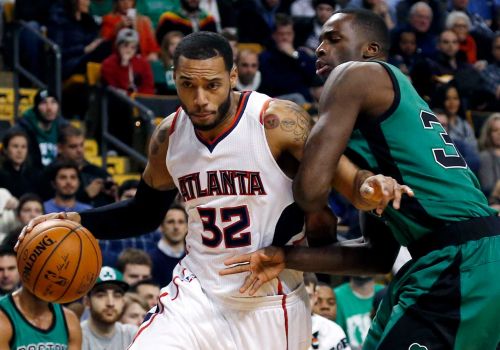 Atlanta Hawks forward Mike Scott drives against Boston Celtics forward Brandon Bass during the first half of an NBA basketball game in Boston. Atlanta Hawks forward Mike Scott has been arrested