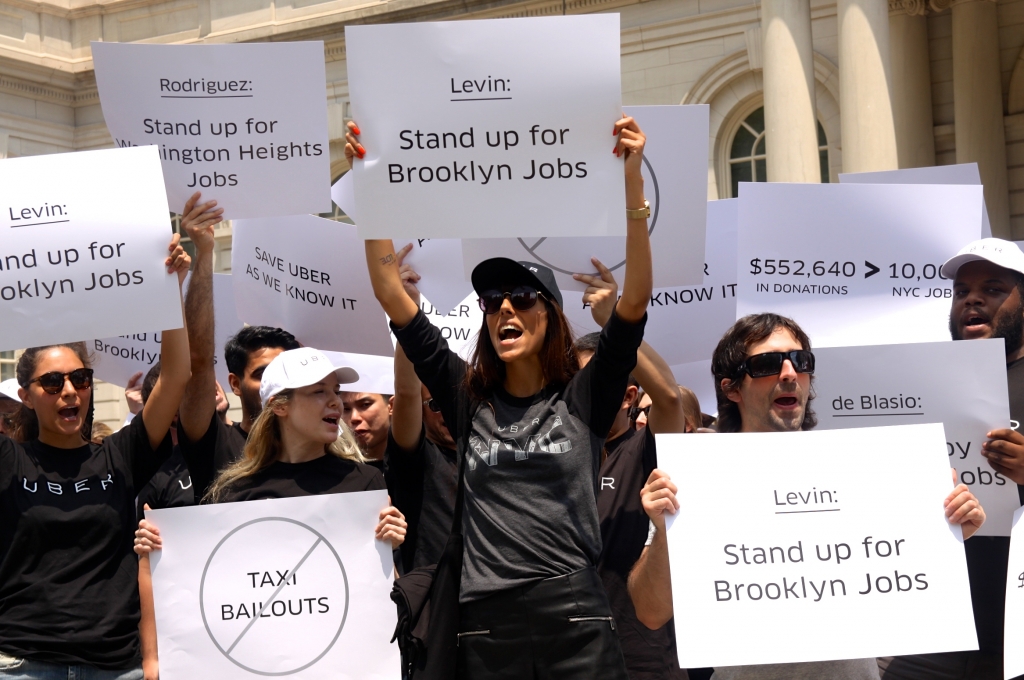 Uber drivers and supporters stood on the steps of City Hall on Tuesday afternoon protesting a proposed bill that could severely limit the number of Uber cars on the road over the next year