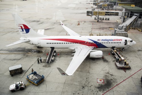 Ground staff load an aircraft operated by Malaysian Airlines System Bhd. at Kuala Lumpur International Airport in Sepang Malaysia on Friday Aug. 8 2014. Malaysia Airlines will be delisted after sovereign wealth fund Khazanah Nasional Bhd