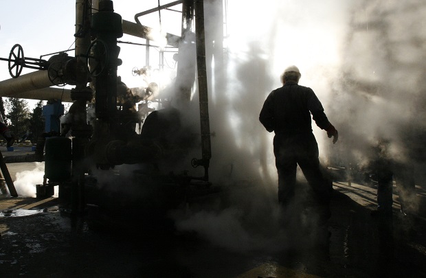 Iranian oil worker makes repairs to a unit at Tehran's oil refinery in Iran. While it will likely be months before sanctions on Iran ease business and political leaders are wasting no time in trying