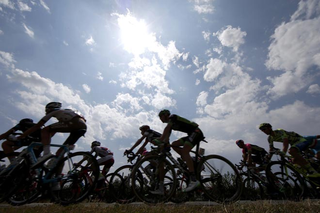 The pack is seen in silhouette as it rides during the 178.5-km 14th stage of the 102nd Tour de France cycling race from Rodez to Mende France. — Reuters