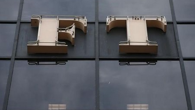 A company logo hangs on the headquarters of the Financial Times newspaper in London. | REUTERS