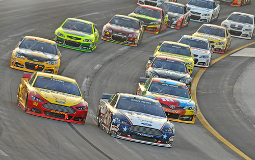 DEFENDING CHAMP Brad Keselowski leads the field while driving to Victory Lane at Kentucky Speedway in 2014. NASCAR has implemented a new rules package to spur more side-by-side racing and passing at this year’s Quaker State 400 at the Sparta