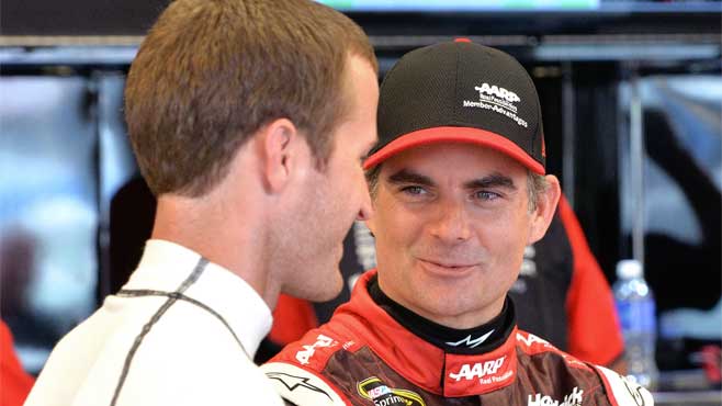 Jeff Gordon right talks with Kasey Kahne as they wait for the track to dry so practice may resume before the NASCAR Xfinity series auto race at Kentucky Speedway in Sparta Ky. Friday