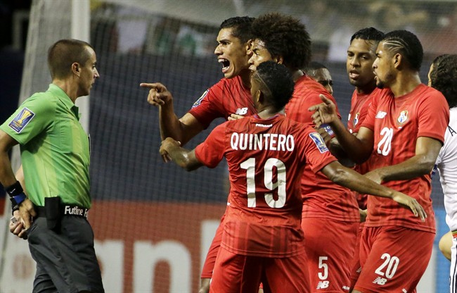 Panama's Valentin Pimentel center right points at referee Mark Geiger who had given a red card to Panama's Luis Tejada not seen during the first half of Panama's CONCACAF Gold Cup soccer semifinal against Mexico on Wednesday