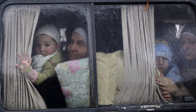 Syrian refugees who fled their home in Idlib due to a government airstrike look out of a vehicle's window just after crossing the border from Syria to Turkey in Cilvegozu Turkey. Marking a tragic milestone the