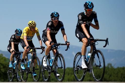 Team Sky rider Chris Froome, wearing the race leader's yellow jersey cycles with team mates during the Tour de France