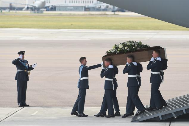 A military honor guard handles the coffin of John Stollery one of the victims of last Friday's Tunisia terrorist attack as it is taken from the RAF C-17 aircraft in England