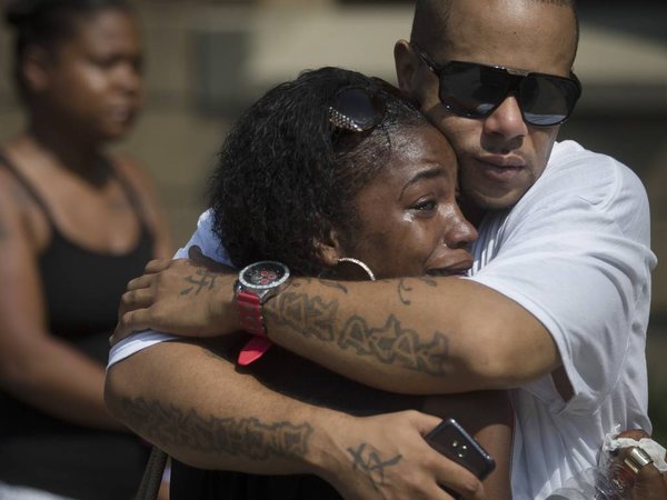 Mourner Shanicca Soloman cries in the embrace of friend Terrell Whitney outside funeral services for Samuel Dubose at the Church of the Living God in the Avondale neighborhood of Cincinnati Tuesday