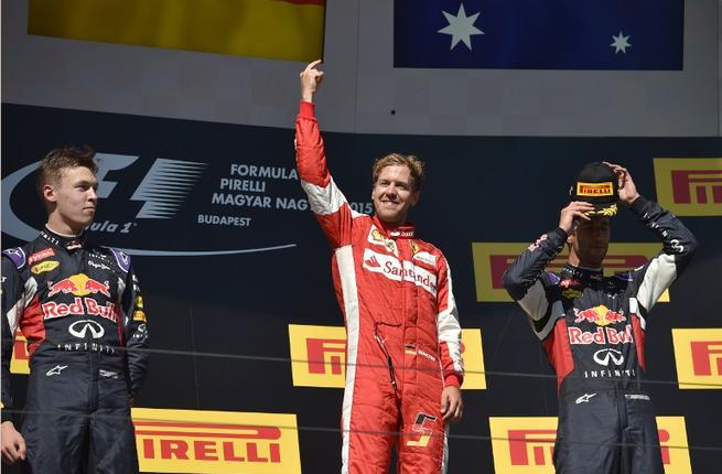 Second placed Daniil Kvyat winner Sebastian Vettel and third placed Daniel Ricciardo celebrate on the podium after the Hungarian Formula One Grand Prix