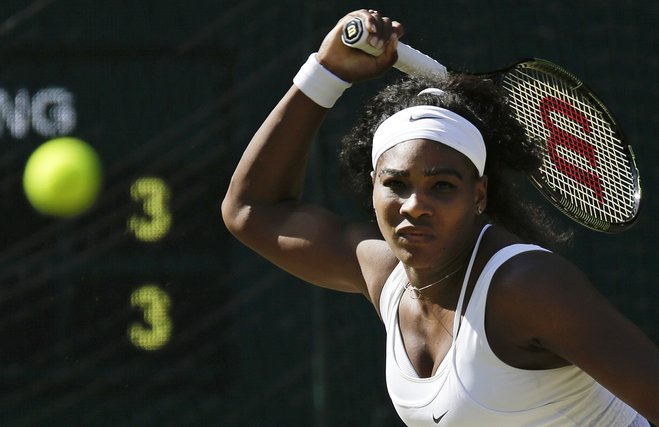 Serena Williams of the United States returns a shot to Maria Sharapova of Russia during the women's singles semifinal match at the All England Lawn Tennis Championships in Wimbledon London Thursday