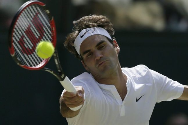 Roger Federer of Switzerland returns to Sam Groth of Australia during their singles match at the All England Lawn Tennis Championships in Wimbledon London Saturday