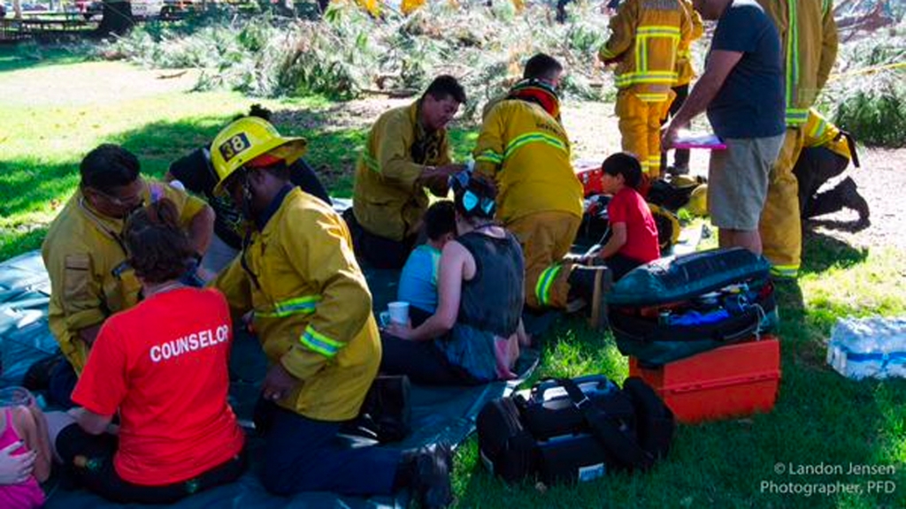 Rescue workers attend to injured children after a tree fell outside the Kidspace Museum in Pasadena