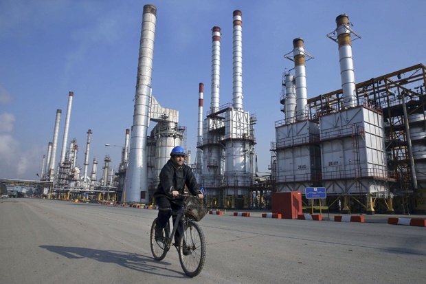 An Iranian oil worker rides his bicycle at the Tehran oil refinery