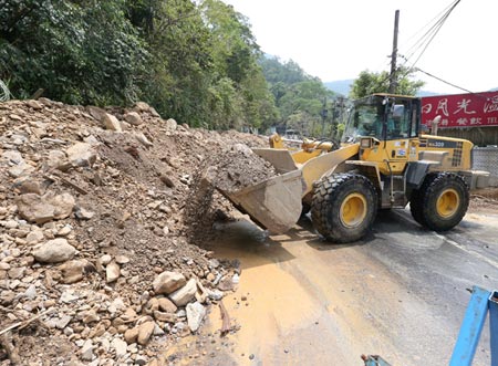 A bulldozer clears a road blocked by a landslide in Wulai Aug. 10