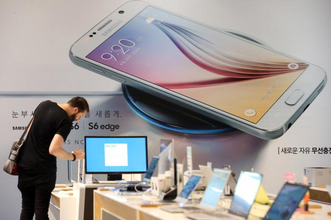 A customer tests a Galaxy S6 phone at a retail shop in southern Seoul on Thursday. Yonhap