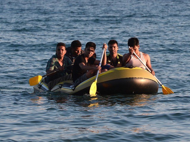 A group of migrants arrive to the shore of Kos island on a small dinghy from Turkey on August 18, 2015